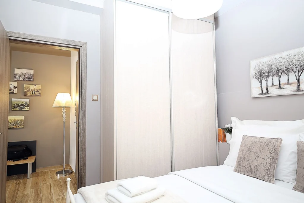 Υπνοδωμάτιο με διπλή ντουλάπα, φωτιστικό δαπέδου και τύπου ξύλινο πάτωμα σε τουριστικό κατάλυμα στην Πορταριά.