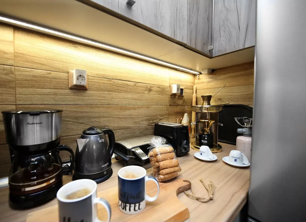 Πλήρως εξοπλισμένος πάγκος κουζίνας με καφετιέρα, βραστήρα, τοστιέρα και ελληνικό μπρίκι.